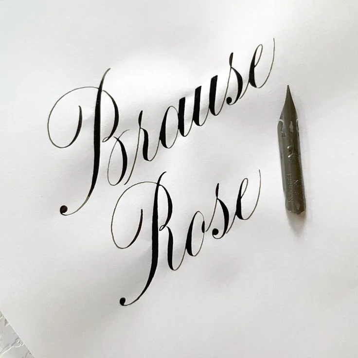 Black Brause Rose calligraphy with contrasting thick and thin strokes beside a metal nib.